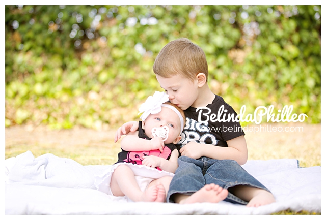 toddler kissing his baby sister
