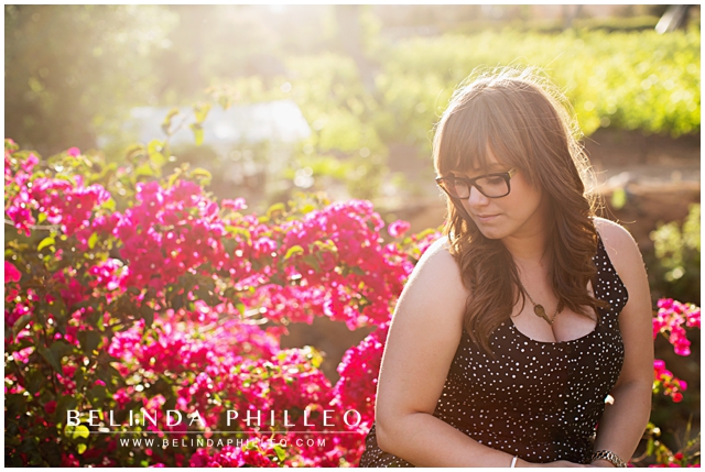 woman sitting among the flowers wearing her giving keys necklace
