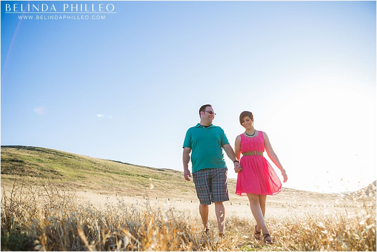 Couple taking a romantic walk through a field in Irvine, CA