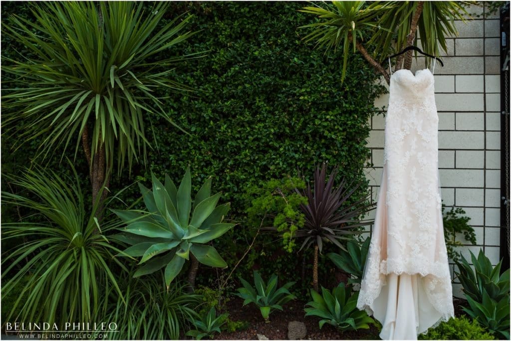 Bridal gown hanging among greenery at Smogshoppe wedding in Los Angeles, CA