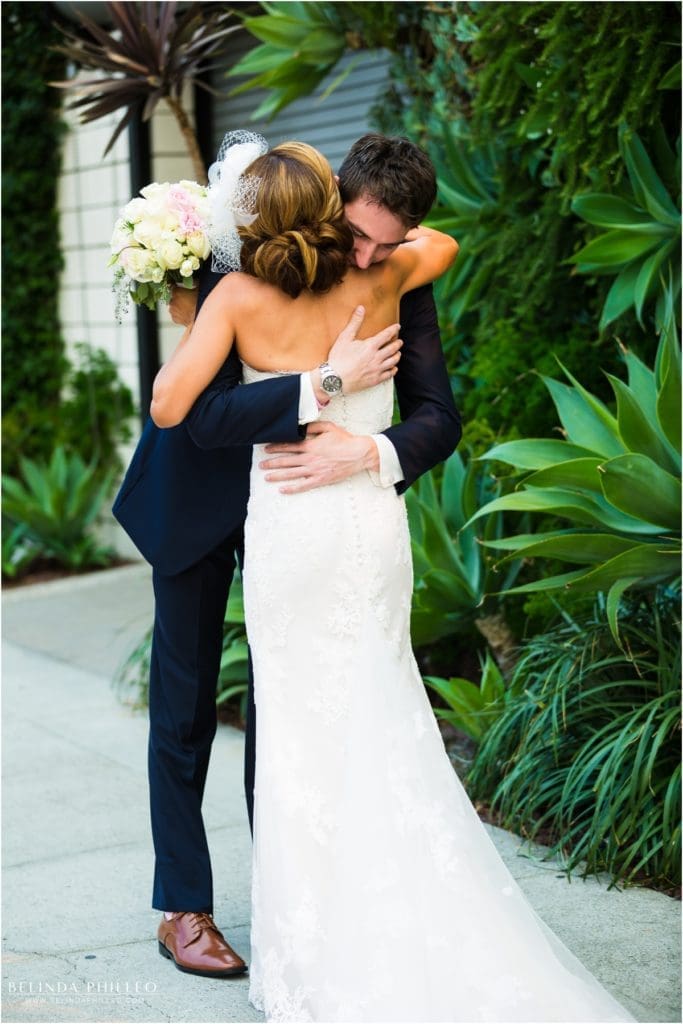 Bride and groom share emotional embrace during first look at Los Angeles Smog Shoppe. Photo by Belinda Philleo