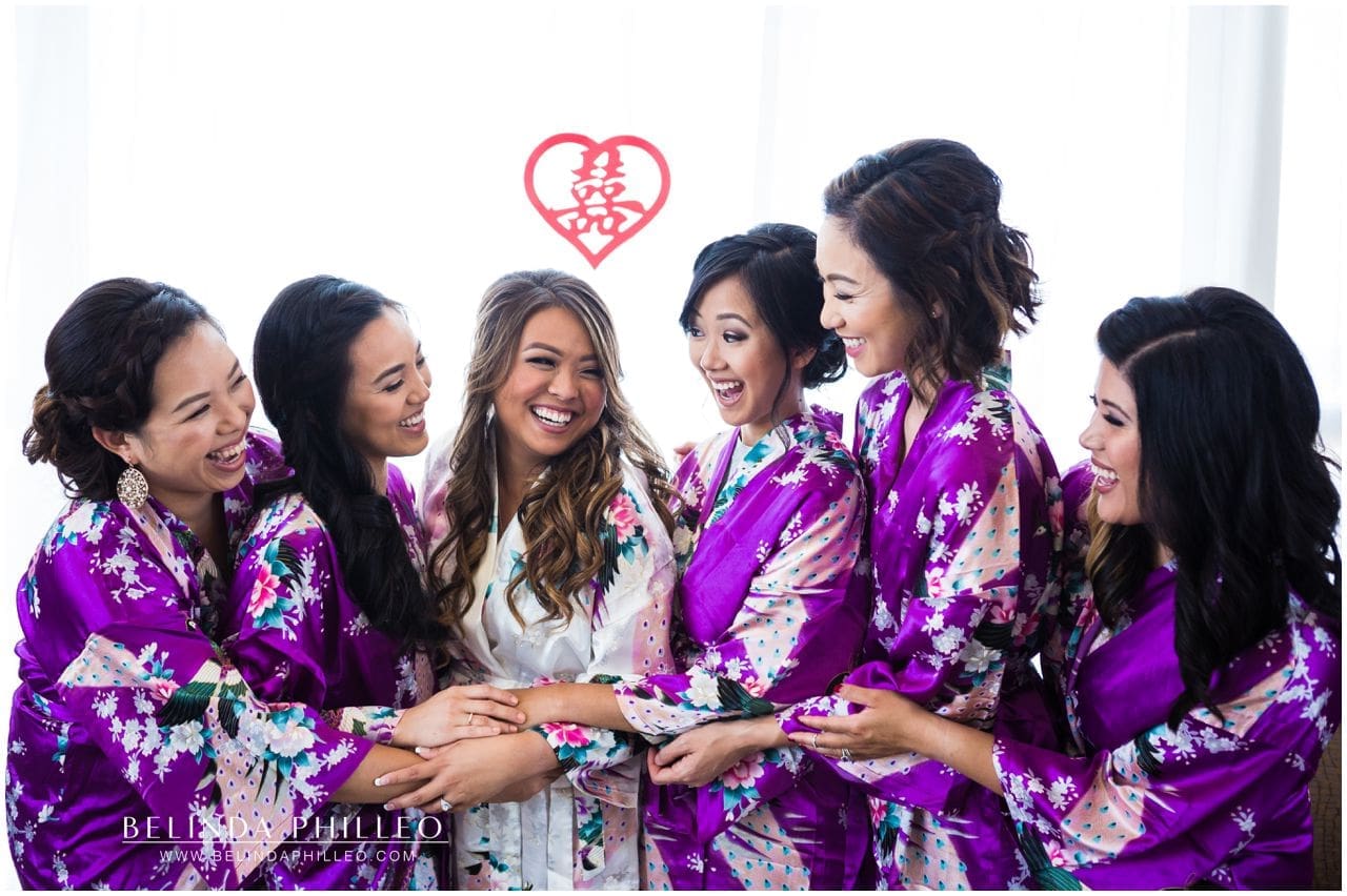 Bride and her bridesmaids get ready for the wedding in silk robes 
