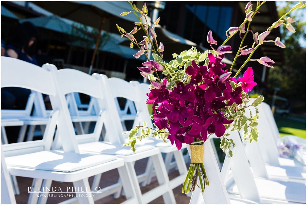 Purple orchids decorate ceremony chairs at Friendly Hills Country Club wedding ceremony