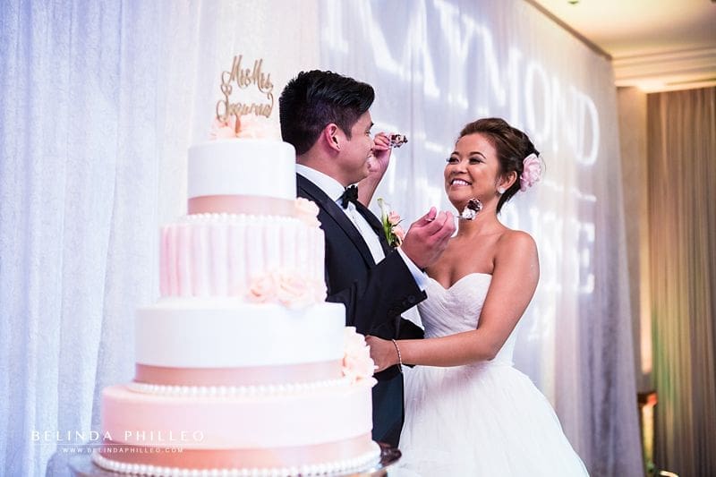 Pink and white tiered wedding cake with buttercream frosting and pink roses