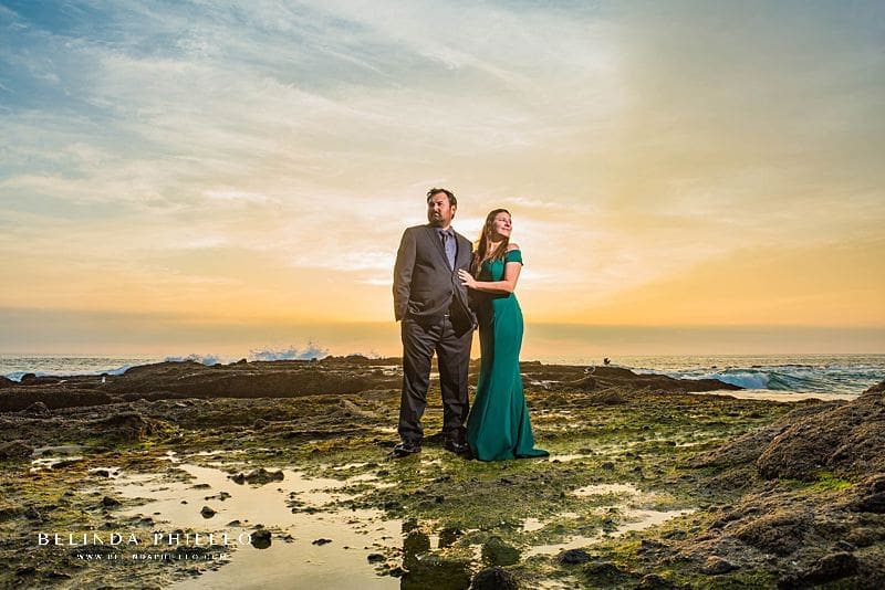 Engagement session locations in Orange County. A couple in formal attire poses for sunset photos on Victoria Beach, CA during their engagement session.