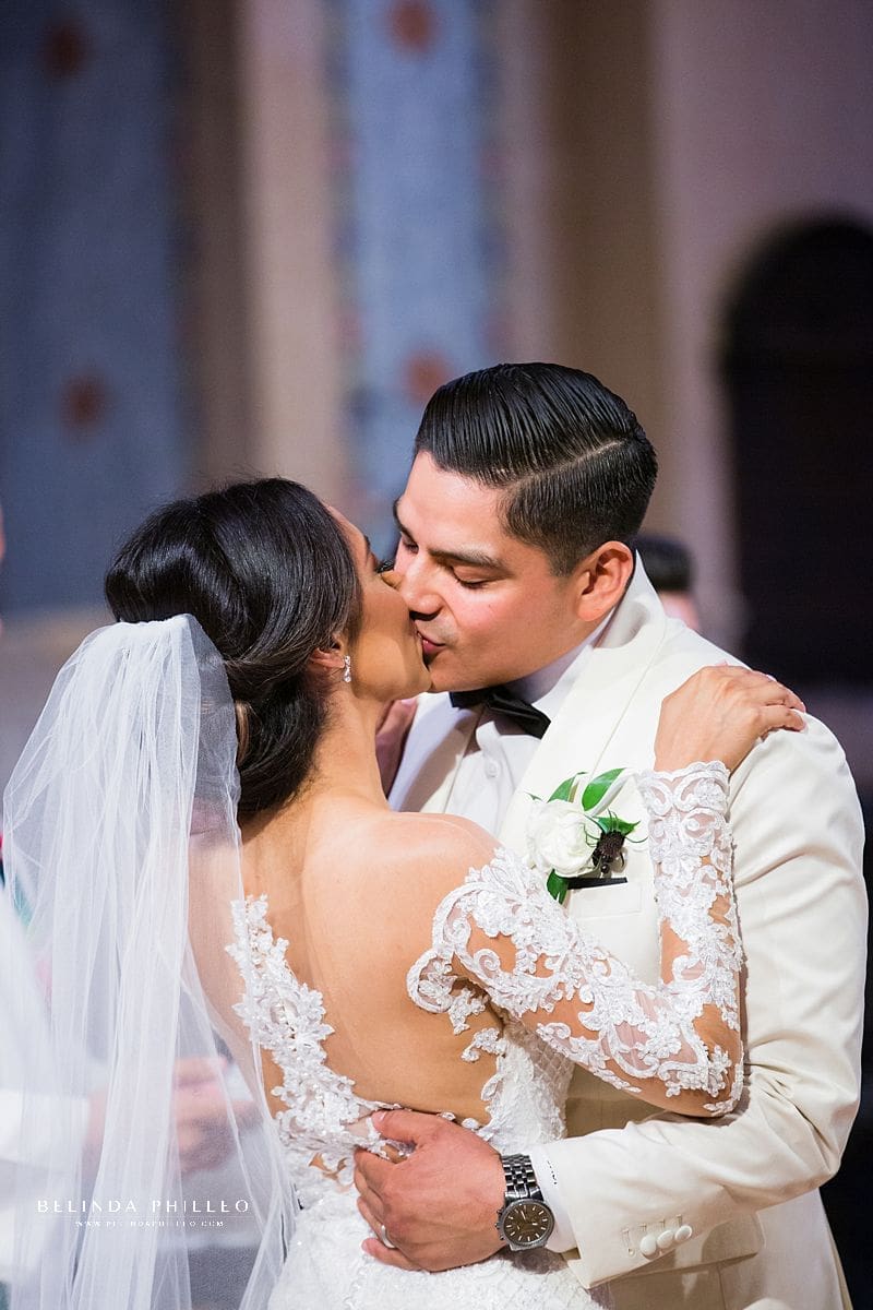 Bride and groom share first kiss during their Los Angeles wedding. Gown by Martina Liana, photo by Belinda Philleo