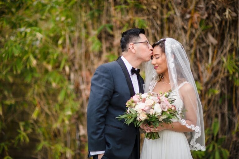 Groom kisses bride during their backyard wedding in Orange County, CA