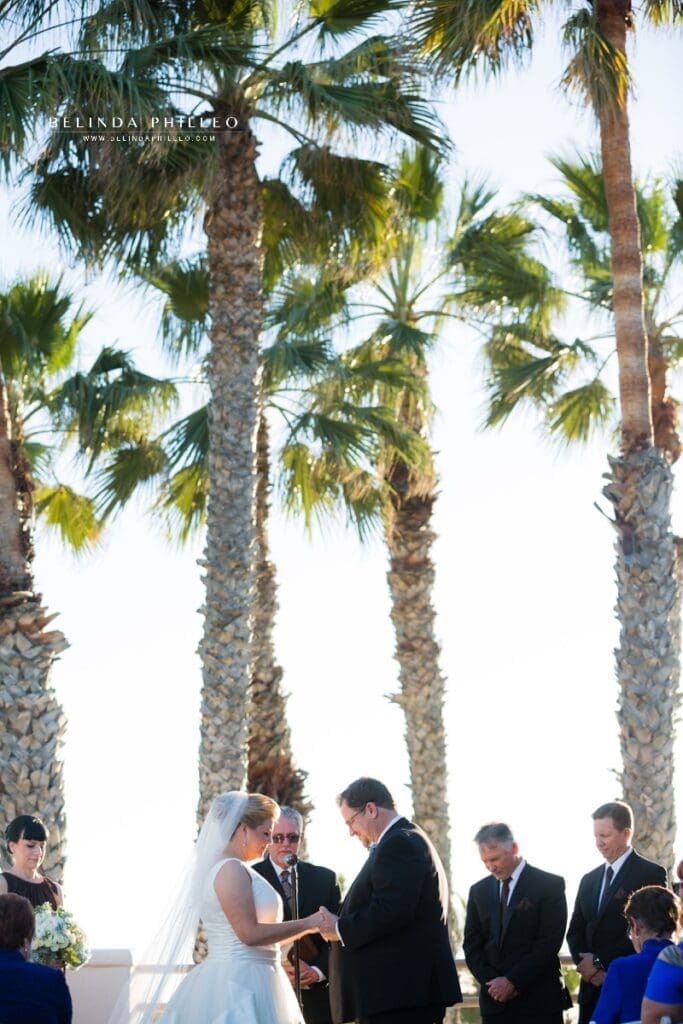 Outdoor wedding ceremony in front of the palm trees at the Hilton Waterfront Resort in Huntington Beach, CA