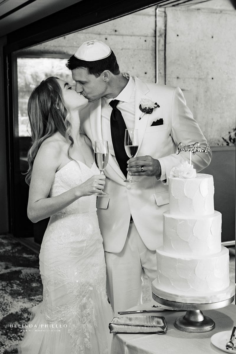 Newlyweds share a kiss after cutting the cake at their Los Angeles, Wedding