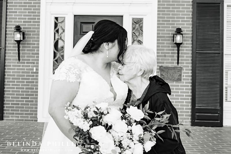 Wedding photos with parents and grandparents. Bride kisses her grandma on her wedding day.