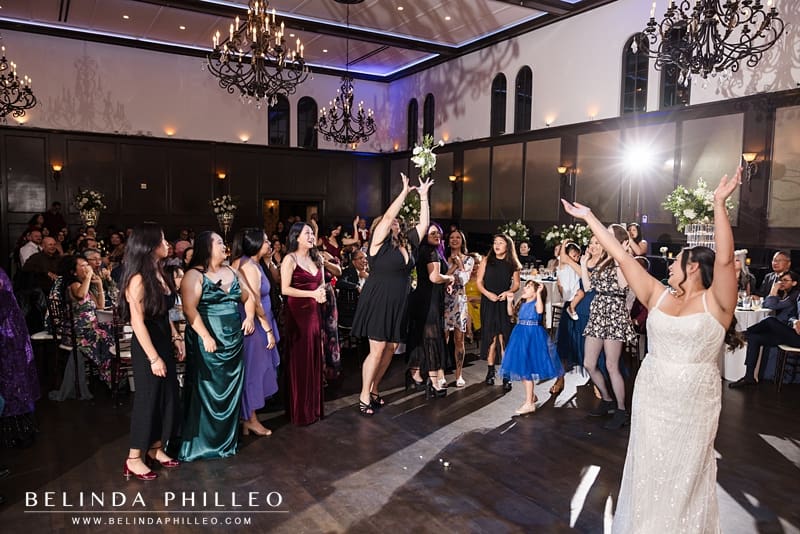 A wedding guest jumps to catch the bouquet after the bride threw it