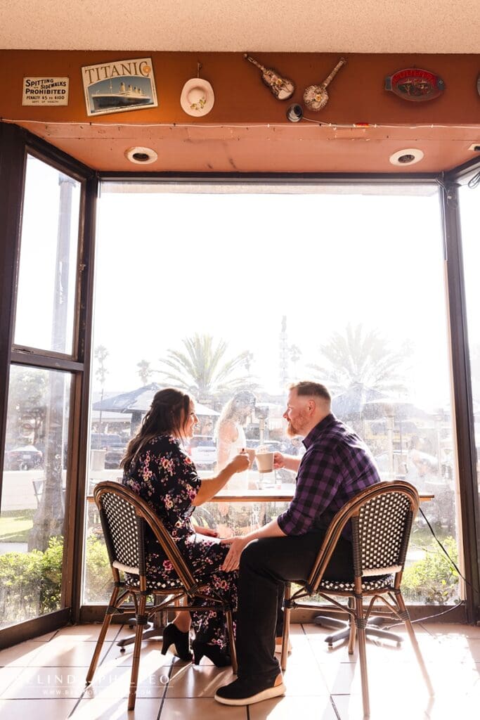 Engaged couple toasts with their coffee mugs at Coffee Cartel in Redondo Beach