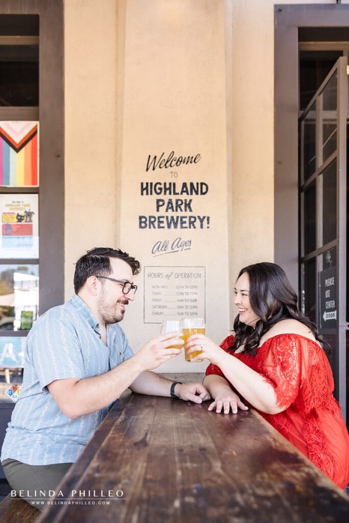 Engaged couple toast with their beers at Higland Park Brewery