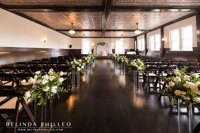 The Petite Ballroom at The Charleston is decorated with white flowers before a wedding ceremony in Fullerton, CA
