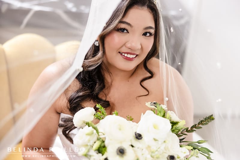 A closeup of the bride smiling underneath her veil